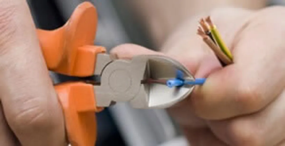 licensed electrician performing precise wire cutting and preparation during electrical service in Bakersfield, CA